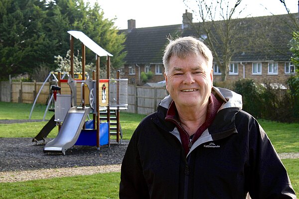 A portrait of James Batho in front of a playground