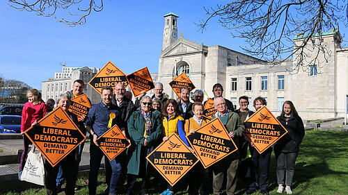 A gathering of Liberal Democrat Supporters holding signs in front of Southampton's Civic centre