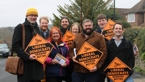 Group of people holding Liberal Democrat Signs